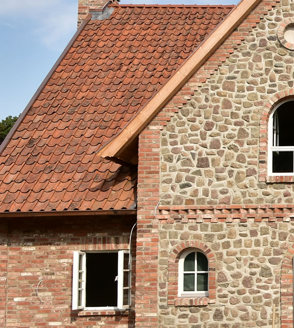 Im Kapitänsgiebel eine Natursteinfassade mit Klinkereinfassung - Bauunternehmen Alan Berry aus Celle, ihr Maurer für englische Cottages und Landhäuser in Celle. Nachhaltiger Hausbau mit historischen Baustoffen. Natursteinfassade und Klinkereinfassung im Kapitänsgiebel - Englische Cottages aus Celle - Bauunternehmen Alan Berry