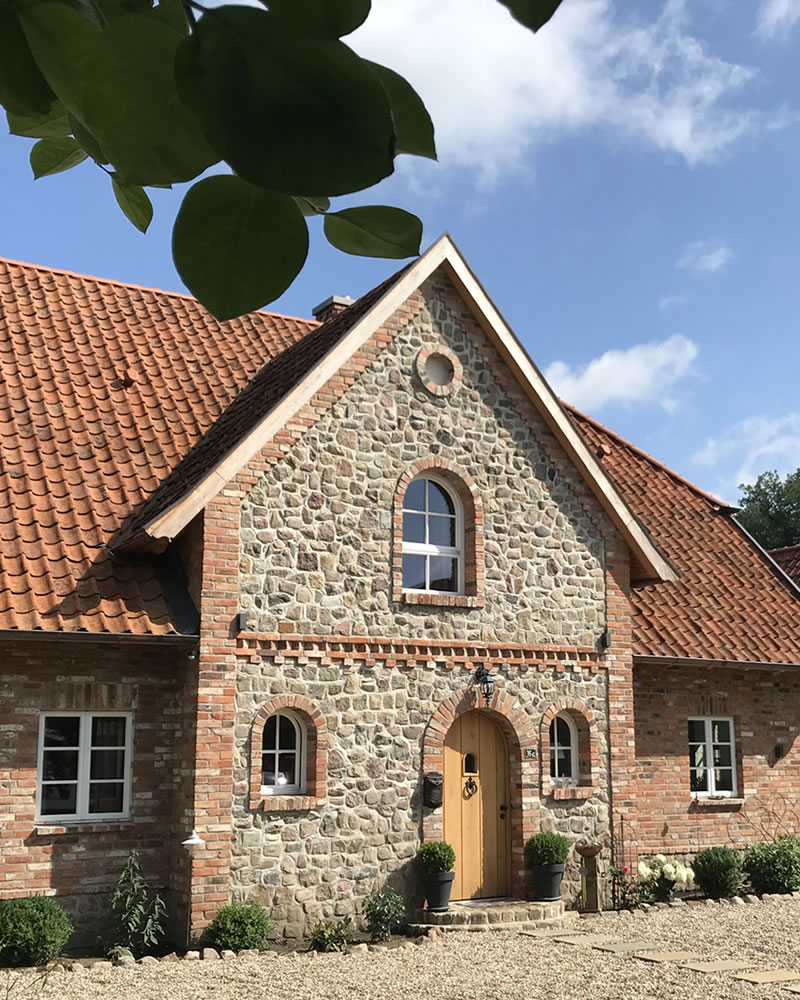 Kapitänsgiebel, Naturstein- und Klinkerfassade eines englischen Landhauses - Bauunternehmen Alan Berry aus Celle, ihr Maurer für englische Cottages und Landhäuser in Celle. Nachhaltiger Hausbau mit historischen Baustoffen. Englisches Landhaus mit Klinkerfassade und Kapitänsgiebel in Naturstein - Englische Cottages aus Celle - Bauunternehmen Alan Berry